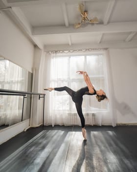 A beautiful Asian woman is dancing at the barre. Ballet dancer