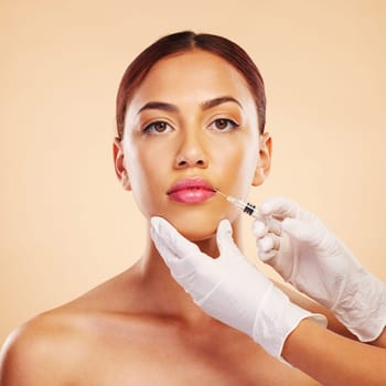 Filler, plastic surgery and face of woman with beauty treatment for isolated in brown studio background. Skincare, cosmetics and portrait of person with syringe for facial or medical transformation.
