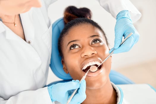 Dentist, black woman and mouth cleaning of patient at a clinic with medical and healthcare for teeth. Mirror, orthodontist and African female person with wellness and dental work tool with care.