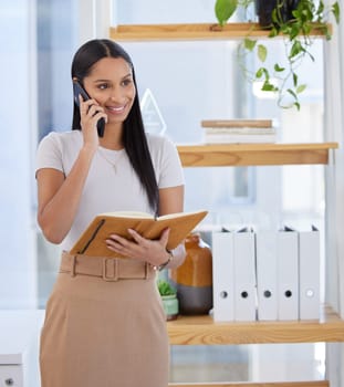 Phone call, planning and notebook with a business woman in her office to schedule an appointment. Mobile, creative and communication with a young female designer talking on her smartphone at work.