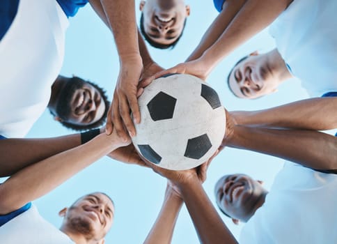 Soccer ball, support or team in a huddle for motivation, goals or group mission for a sports game or match. Smile, sky or low angle of happy football players in exercise, workout or fitness training.