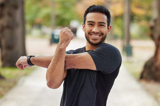 Happy asian man, portrait and stretching arms in fitness getting ready for running, workout or exercise at the park. Male person or runner with smile in warm up arm stretch, training or run in nature.