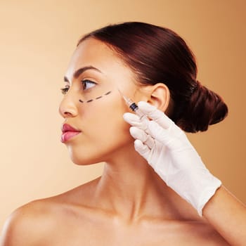 Injection, plastic surgery and face of woman with beauty treatment for isolated in brown studio background. Skincare, cosmetics and young person with syringe for facial or medical transformation.