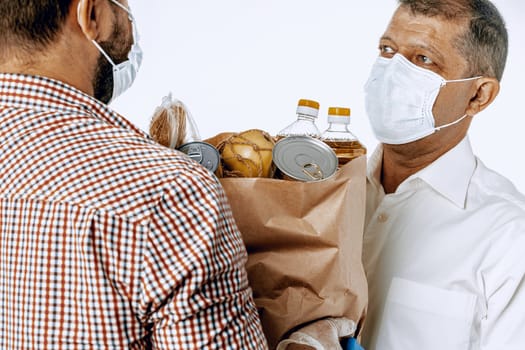 Delivery man in face mask and gloves. Food delivery, online shopping concept while coronavirus pandemia worldwide