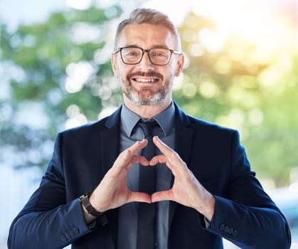 Face, business man and ceo with heart hands outdoor for trust, care and happy. Portrait, mature with love sign, smile for kindness or empathy, charity or gratitude, romance emoji or support.