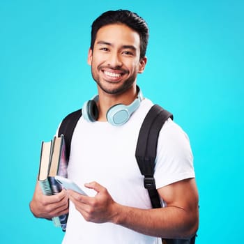 Indian, college student and portrait with phone in studio and backpack for university, education and connection on blue background. Happy, man and person excited to study and learn for future goals.