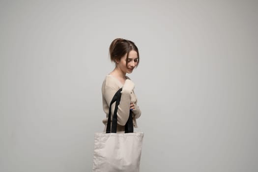 Young brunette woman with white cotton bag. Eco friendly lifestyle. Reuse, recylce, zero waste, No more plastic