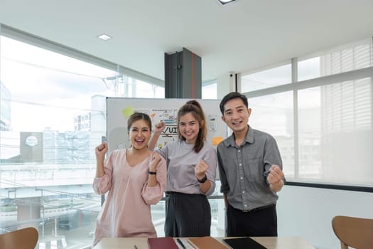 Asian female leader and ux ui designer clapping hand for successful of mobile app interface wireframe design at modern office. Creative digital development agency.