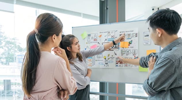 group of asian ux developer and ui designer serious brainstorming about mobile app interface on meeting at modern office.Creative digital development agency.