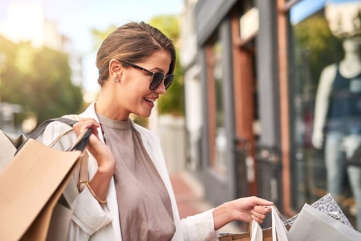 Fashion, shopping bag or happy rich woman in city walking on urban street for boutique retail sale or clothes. Sunglasses, financial freedom or girl customer on road searching for luxury products.