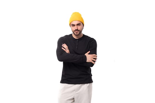 young caucasian brunette man with a beard in a casual sweatshirt stands confidently on a white background with copy space.