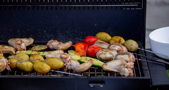 a man is grilling vegetables and meat. Selective focus. Nature