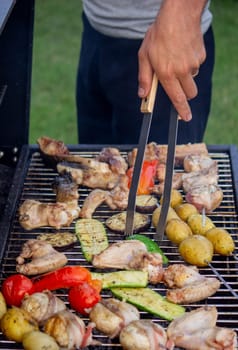 a man is grilling vegetables and meat. Selective focus. Nature