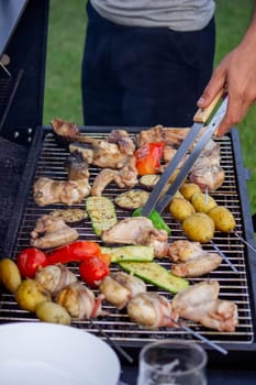 a man is grilling vegetables and meat. Selective focus. Nature