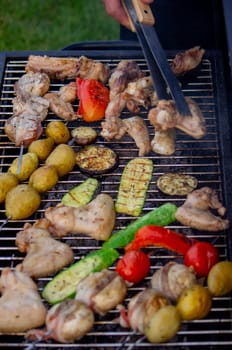 a man is grilling vegetables and meat. Selective focus. Nature