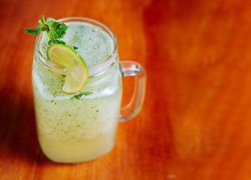 Refreshing lemonade with mint on wooden table. Lemonade drink on wooden table