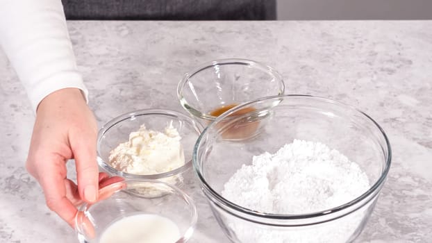 Step by step. Ingredients in a glass mixing bowl to prepare cream cheese frosting.