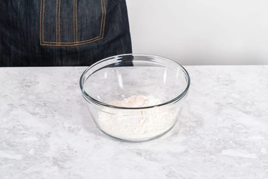 Mixing ingredients in a glass mixing bowl to bake July 4th bundt cake with chocolate stars.