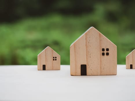 Concept of selling a house. Model house on a nature background. Real estate agent offer house, property insurance and security, affordable housing concepts, home insurance broker agent, salesman person.