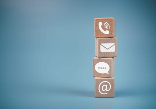 Stacked wooden blocks and communication icons. Website page, contact us or email marketing concept, customer support hotline, contact us, email, phone, address, chat message icon.