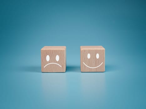Mental health and emotional state concept, Smile face  and sad face on wooden block cube for positive mindset selection concept.