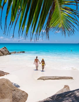 Anse Lazio Praslin Seychelles, a young couple of men and women on a tropical beach during a luxury vacation in Seychelles. Tropical beach Anse Lazio Praslin Seychelles Islands