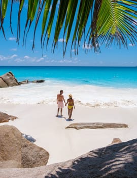 Anse Lazio Praslin Seychelles, a young couple of men and women on a tropical beach during a luxury vacation in Seychelles.