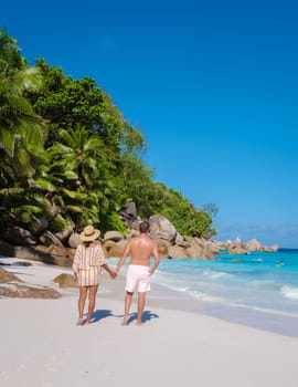 Anse Lazio Praslin Seychelles, a young couple of men and women on a tropical beach during a luxury vacation in Seychelles. Tropical beach Anse Lazio Praslin Seychelles Islands on a sunny day