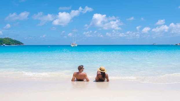 a young couple of men and women on a tropical beach during a luxury vacation in the Seychelles. Tropical beach Anse Lazio Praslin Seychelles Islands