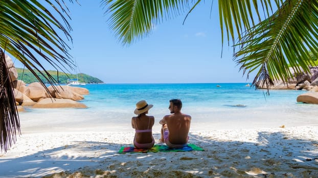 a young couple of men and women on a tropical beach during a luxury vacation in the Seychelles. Tropical beach Anse Lazio Praslin Seychelles Islands