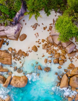 Anse Lazio Praslin Seychelles is a young couple of men and women on a tropical beach during a luxury vacation there. Tropical beach Anse Lazio Praslin Seychelles tropical Islands