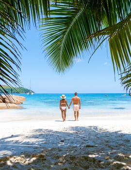 Anse Lazio Praslin Seychelles is a young couple of men and women on a tropical beach during a luxury vacation there. Tropical beach Anse Lazio Praslin Seychelles tropical Islands