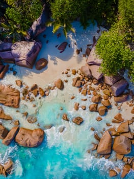 Anse Lazio Praslin Seychelles, a young couple of men and women on a tropical beach during a luxury vacation at the Seychelles. Tropical beach Anse Lazio Praslin Seychelles Islands drone aerial view