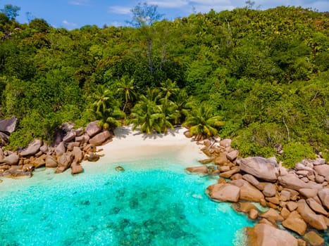 Anse Lazio Praslin Seychelles, a young couple of men and women on a tropical beach during a luxury vacation at the Seychelles. Tropical beach Anse Lazio Praslin Seychelles Islands drone aerial view