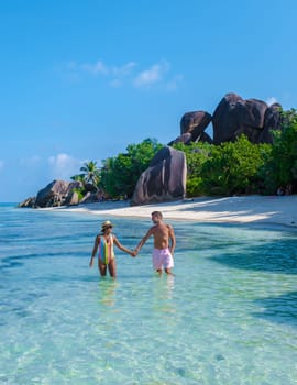 Anse Source d'Argent, La Digue Seychelles, a young couple of men and women on a tropical beach during a luxury vacation in Seychelles. Tropical beach Anse Source d'Argent, La Digue Seychelles