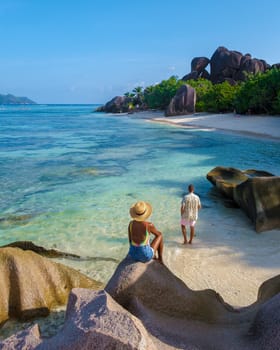 a young couple of men and women on a tropical beach during a luxury vacation in Seychelles. Tropical beach Anse Source d'Argent, La Digue Seychelles