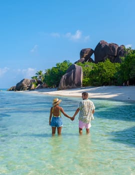 Anse Source d'Argent, La Digue Seychelles, a young couple of men and women on a tropical beach during a luxury vacation in Seychelles. Anse Source d'Argent, La Digue Seychelles