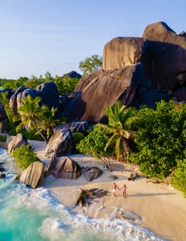 Anse Source d'Argent, La Digue Seychelles, a young couple of men and women on a tropical beach during a luxury vacation in Seychelles islands