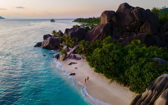 Anse Source d'Argent, La Digue Seychelles, a young couple of men and women on a tropical beach during a luxury vacation at the Seychelles.