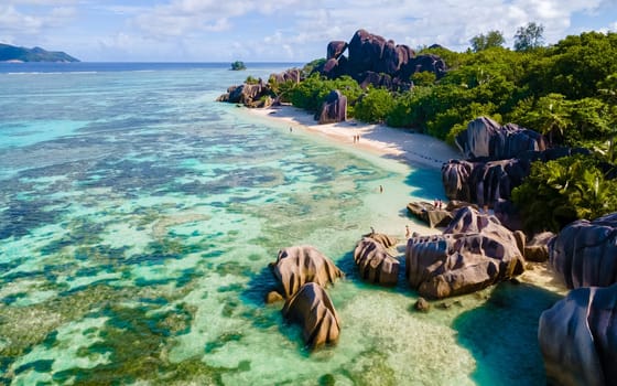 Anse Source d'Argent, La Digue Seychelles, a young couple of men and women on a tropical beach during a luxury vacation at the Seychelles.