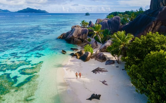 Anse Source d'Argent, La Digue Seychelles, a young couple of men and women on a tropical beach, drone aerial view of a tropical beach at the Seychelles Islands