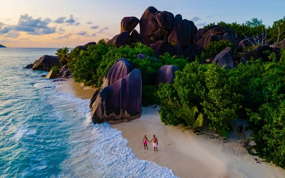 drone aerial view at Anse Source d'Argent, La Digue Seychelles, a young couple of men and women on a tropical beach during a luxury vacation in Seychelles. Tropical beach Anse Source d'Argent, La Digue Seychelles