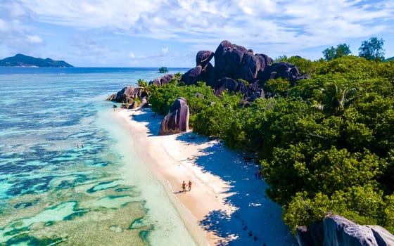 Anse Source d'Argent, La Digue Seychelles, a young couple of men and women on a tropical beach during a luxury vacation at the Seychelles. Tropical beach Anse Source d'Argent, La Digue Seychelles