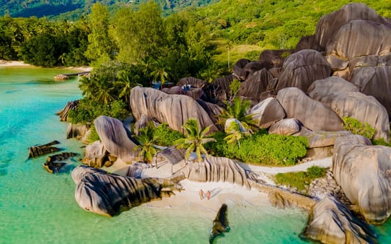 Anse Source d'Argent, La Digue Seychelles, a young couple of men and women on a tropical beach, drone aerial view of a tropical beach at the Seychelles Islands