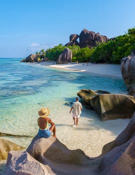 Anse Source d'Argent, La Digue Seychelles, a young couple of men and women on a tropical beach during a luxury vacation in Seychelles. Tropical beach Anse Source d'Argent, La Digue Seychelles