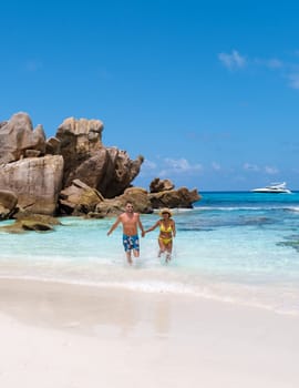 Anse Cocos La Digue Seychelles, a young couple of men and women on a tropical beach during a luxury vacation in Seychelles.