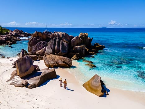 Anse Cocos La Digue Seychelles, a young couple of men and women on a tropical beach during a luxury vacation in Seychelles. Tropical beach Anse Cocos La Digue Seychelles with a blue ocean