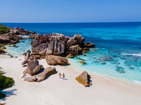 Anse Cocos La Digue Seychelles, couple of men and women on a tropical beach during a luxury vacation in Seychelles. Tropical beach Anse Cocos La Digue Seychelles.