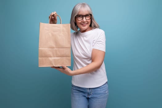 middle aged woman holding shopping bag on studio background.