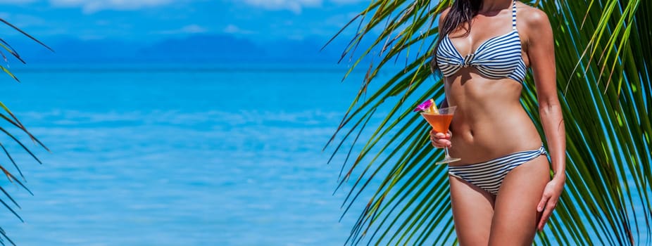 Beautiful woman with cocktail posing on tropical beach